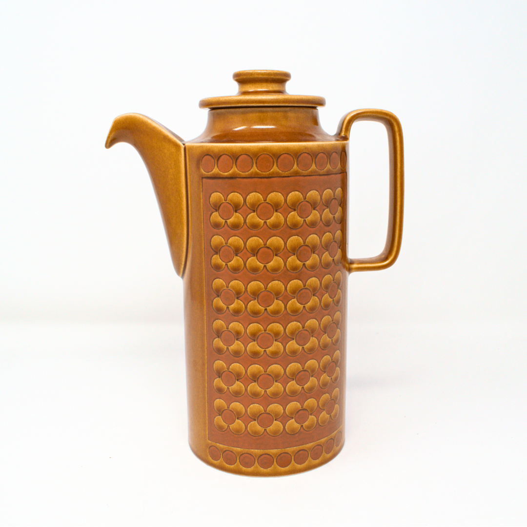 Brown ceramic coffee pot with textured design on a white background