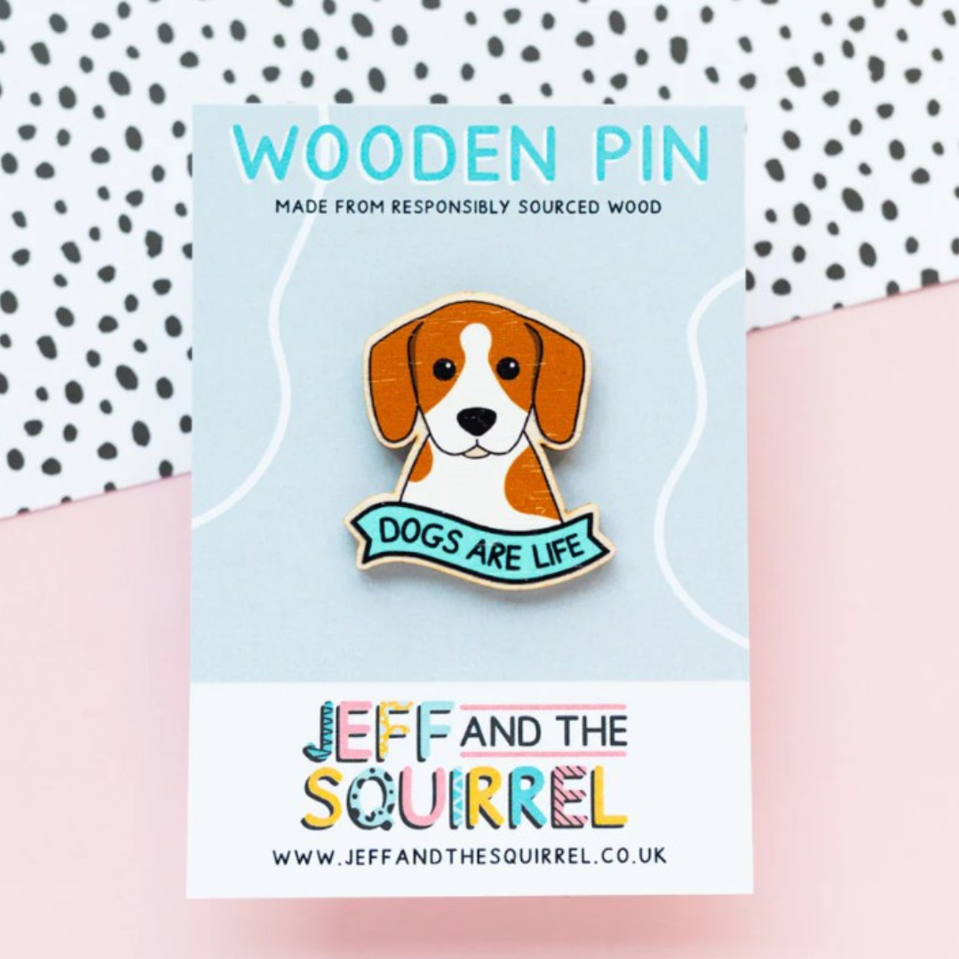 Wooden pin with dog illustration and 'Dogs are Life' text on a card with 'Jeff and the Squirrel' branding.