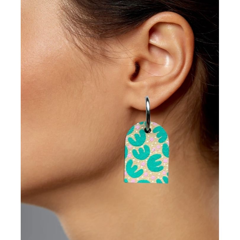 Earring with a green and pink pattern worn by a person