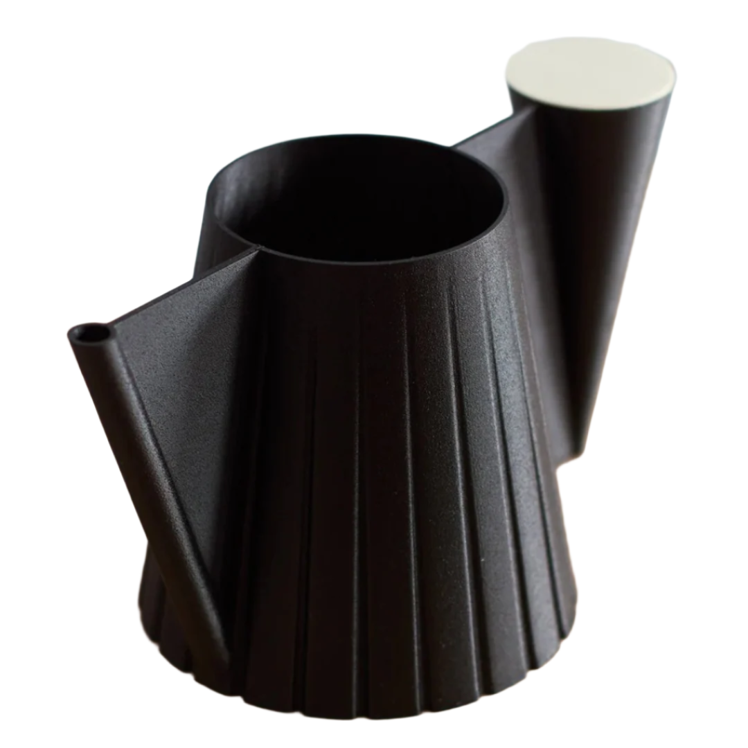 Black pleated teapot on a wooden surface with a light background