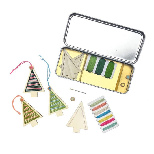 Colorful thread spools and wooden tree shapes on a white background