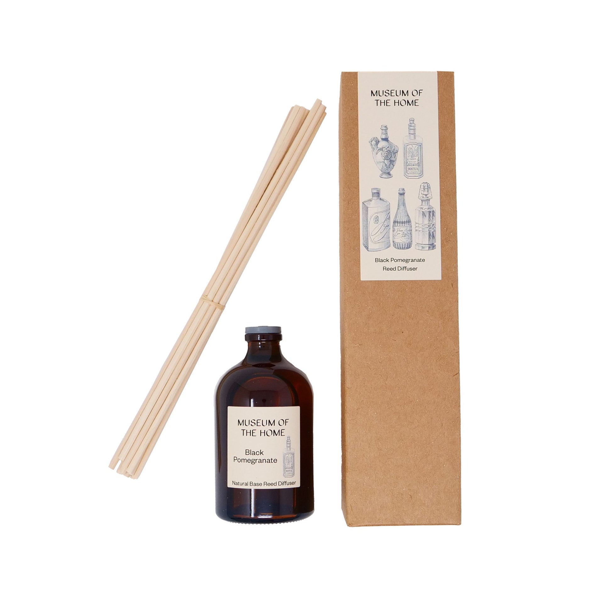 Diffuser oil in scent 'black pomegranate' in brown glass container; diffuser sticks in front of cardboard packaging with 'apothecary' design on label.