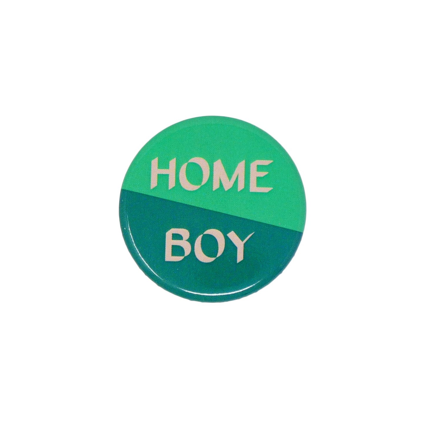 Close up of Home Boy badge with half light green and half dark green background separated diagonally. With 'Home boy' in light peach font.