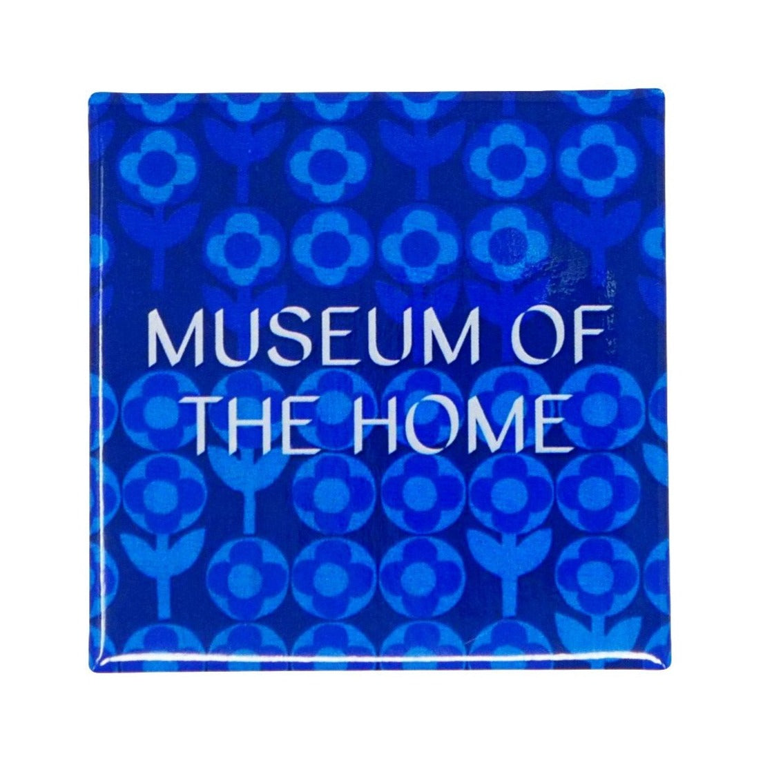 Blue magnet with light blue geometric daises. Museum of the Home logo is written in white.