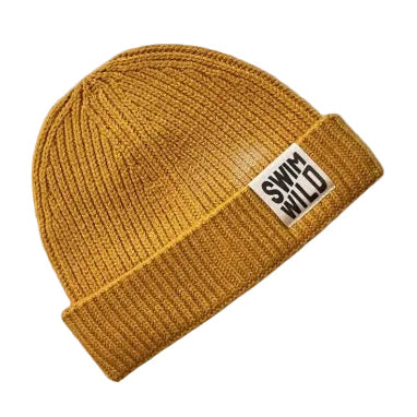 Mustard yellow beanie with a label on a white background