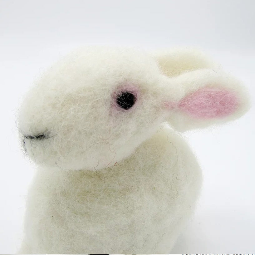 Close-up of a needle felted white bunny toy on a white background