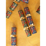 Green and red packages of crackers. The wrapping features folk Christmas images with details in red, green and gold. 
