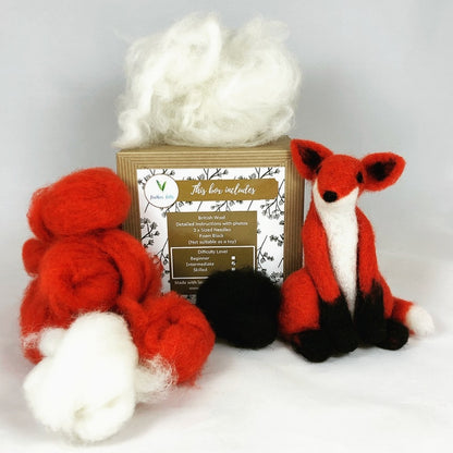 Red fox wool toy with craft materials and a branded box on a white background