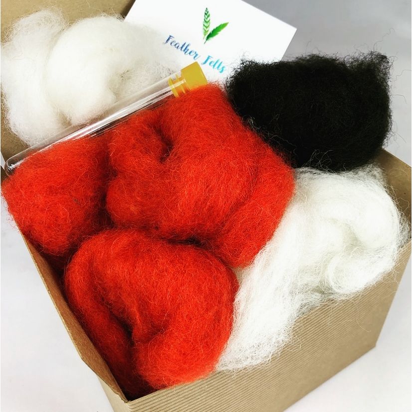 Box containing red, black, and white fibers with a brand label on a gray background