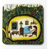 A coaster with an illustration of a mouse sleeping in its bed, covered by a blue blanket inside its house. There is a window with the moon and the stars, a green lamp, a small mirror and a shelf on top of the bed.