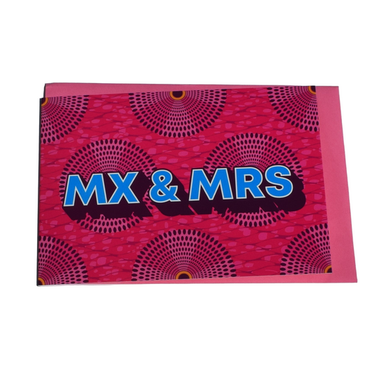 A greeting card with a pink background and blue text that reads 'MX & MRS' in a bold, circular pattern.