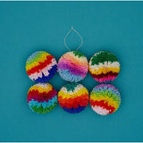 Six colourful paper pompoms on a blue background.
