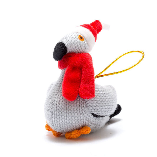 A small knitted plush bird ornament in light gray with a red scarf, red Santa hat, black beak and tail details, orange feet, and a yellow hanging loop, photographed on a clean white background.