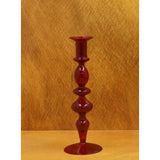 A red candle holder with oval details on a golden yellow background.