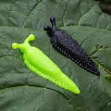 Plastic slugs in green and black against a leaf background.