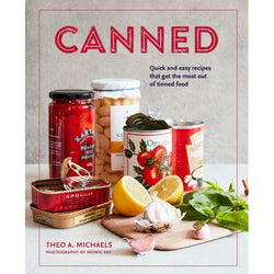 Copy of Canned by Theo A. Michaels. Title is printed in a red graphic font. The cover has a photograph of a selection of cans and tins against a white background. Subtitle reads: 