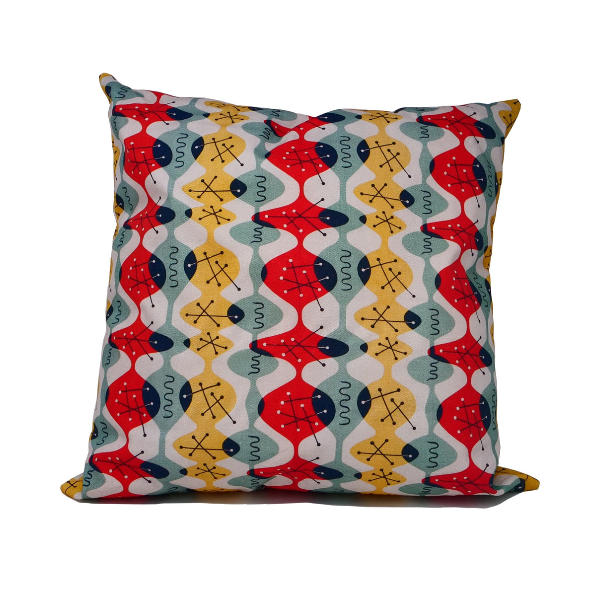 Cushion cover with white background and fluid red, green and yellow ovoid shapes with black atomic structures. 