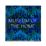 Blue and green patterned magnet with Museum of the Home logo written in white. 