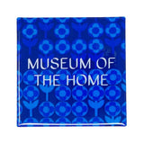 Blue magnet with light blue geometric daises. Museum of the Home logo is written in white. 