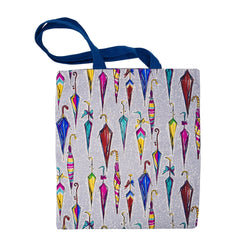 Tote bag with navy blue straps and a grey and white mottled background with various umbrella illustrations in mainly pink, red, blue and yellow. 