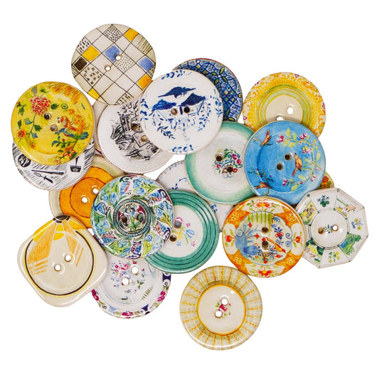 Pile of 20 assorted ceramic buttons with varying patterns. Common colours throughout are black, blue, white, green and yellow. 