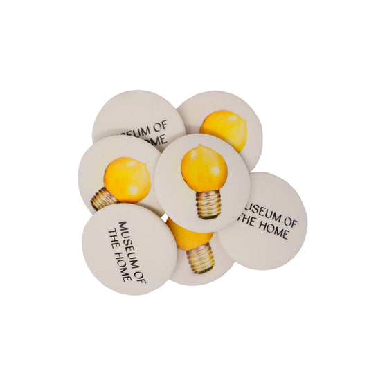 Pile of flat round erasers with image of lightbulb on front and Museum of the Home logo on the back. 