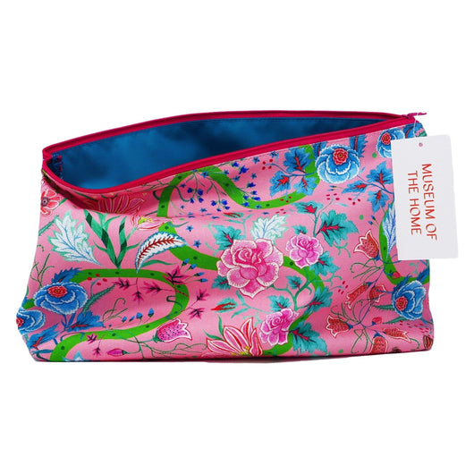 Wash bag with light pink background and dark pink,  red and blue flowers with green stems and swirled lines. Also has red zip and lining as well as blue inner lining.  