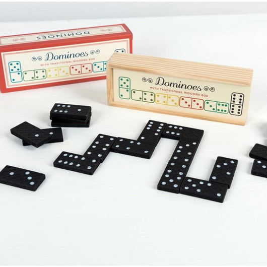 Black pieces of dominoes with white dots. A wooden box to keep the pieces is behind and a carton box behind as well.