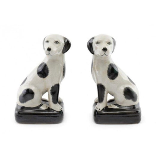 Two white with black spots porcelain dogs. One is on the right and one is on the left.