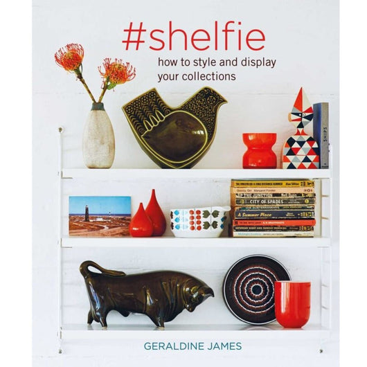 Copy of Shelfie by Geraldine James; cover features a photograph of shelves with a variety of trinkets. Cover is white and features the book title in a red font. Subtitle reads: 